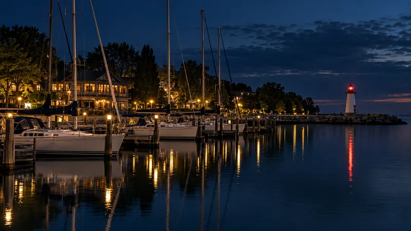 Sailboats moored at Bronte Harbour marina with a lighthouse pier in Bronte Village at dusk